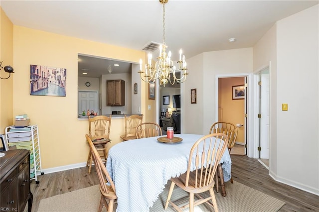 dining area featuring dark hardwood / wood-style flooring and a chandelier