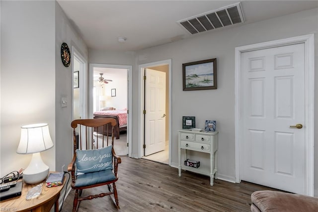 living area with ceiling fan and dark hardwood / wood-style flooring