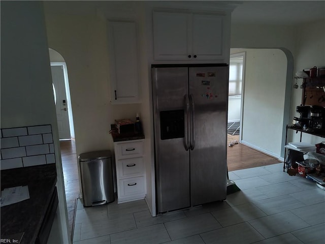 kitchen featuring stainless steel fridge with ice dispenser and white cabinets