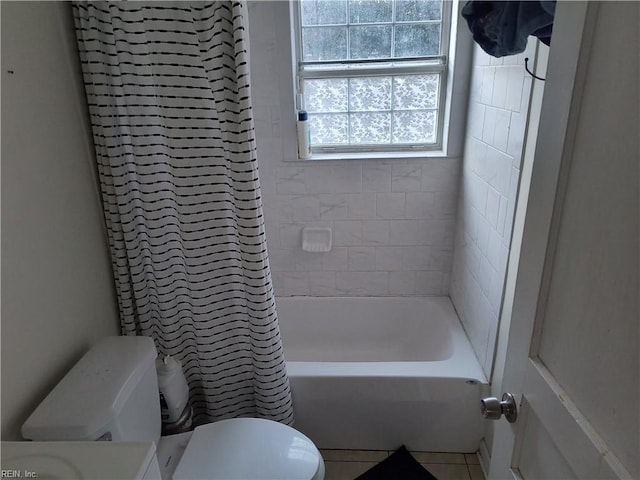 bathroom with tile patterned flooring, toilet, and tiled shower / bath