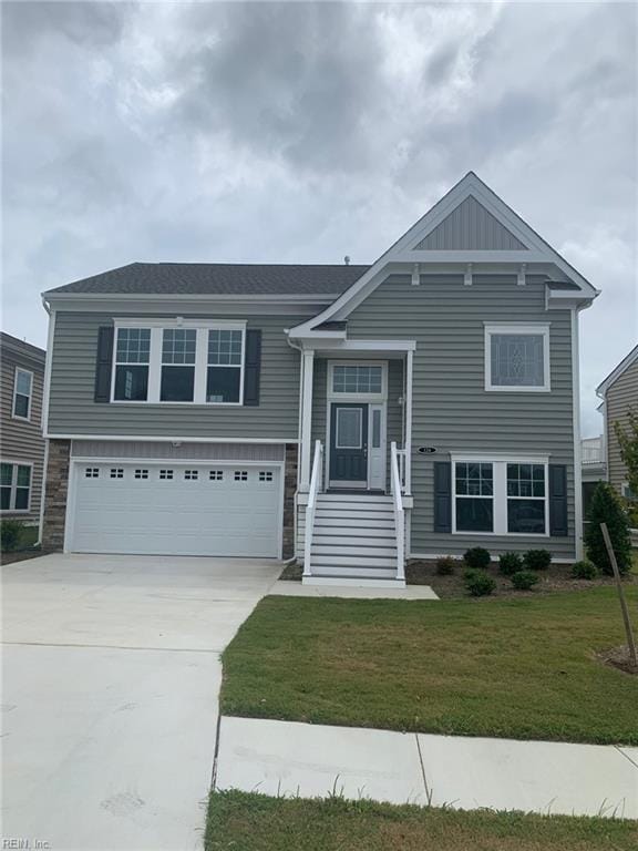 bi-level home featuring a garage and a front lawn