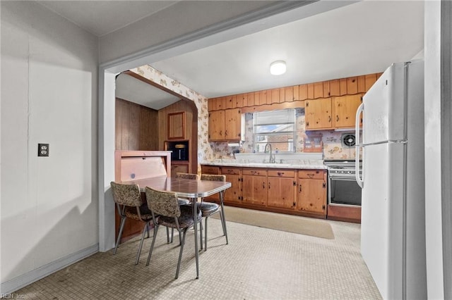 kitchen with sink, stainless steel range oven, and white refrigerator