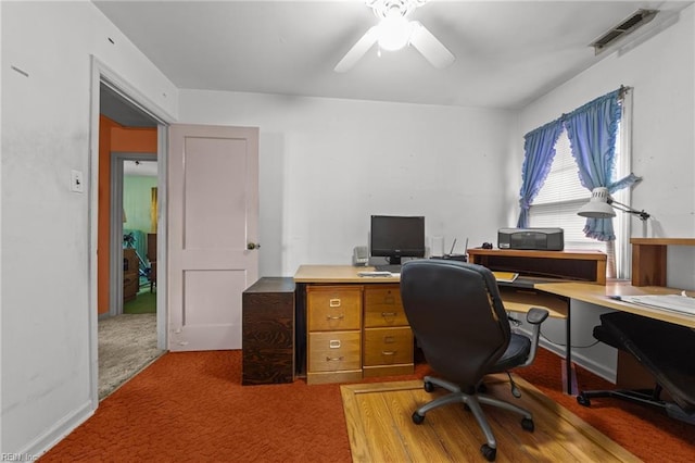 carpeted home office featuring ceiling fan