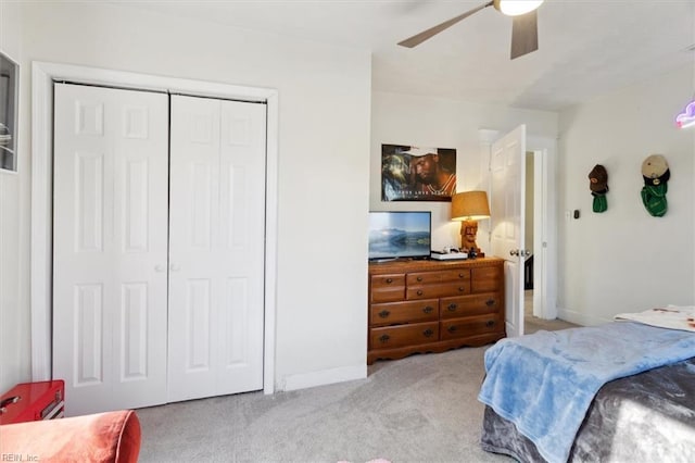 carpeted bedroom featuring ceiling fan and a closet