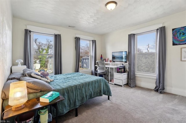 bedroom featuring a textured ceiling and light carpet