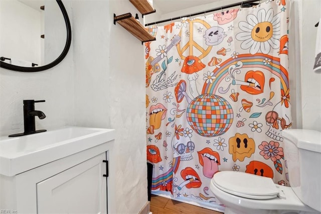 bathroom with hardwood / wood-style floors, vanity, a shower with shower curtain, and toilet