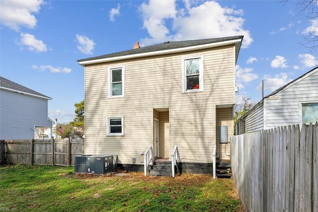 back of house with a lawn and cooling unit