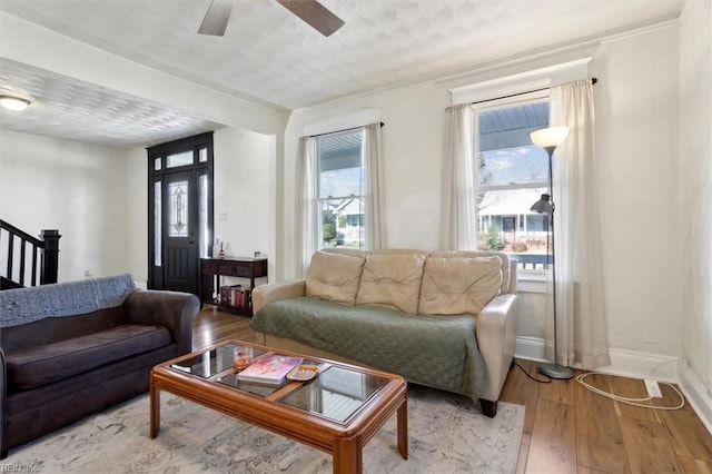 living room featuring ceiling fan, light hardwood / wood-style floors, and a textured ceiling