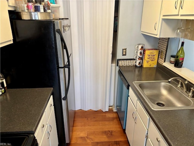 kitchen featuring dark wood-type flooring, stainless steel appliances, white cabinets, and sink