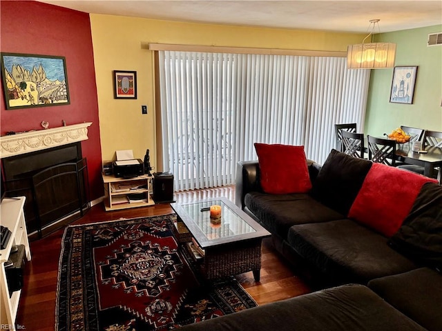 living room featuring dark wood-type flooring and a notable chandelier