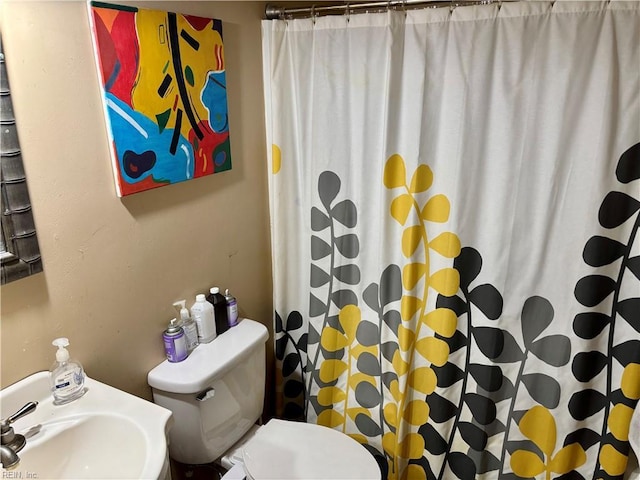 bathroom with toilet, a shower with curtain, and sink