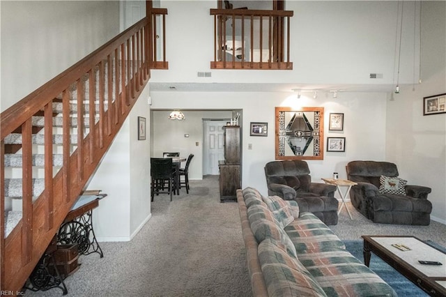 carpeted living room with a towering ceiling