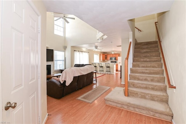 living room with ceiling fan and light wood-type flooring