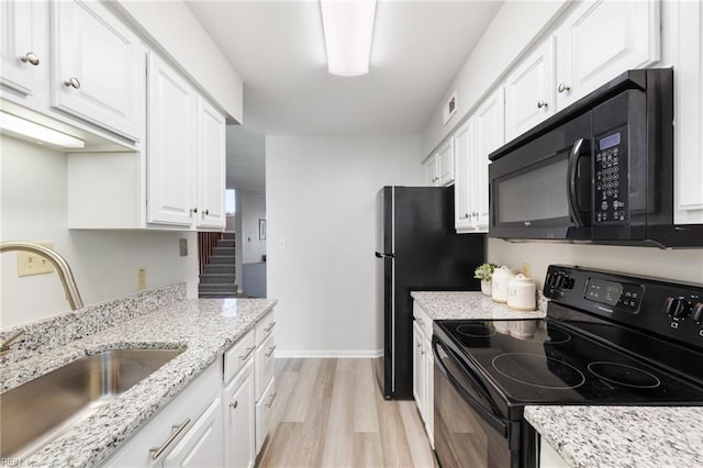 kitchen featuring light stone counters, sink, black appliances, light hardwood / wood-style floors, and white cabinetry