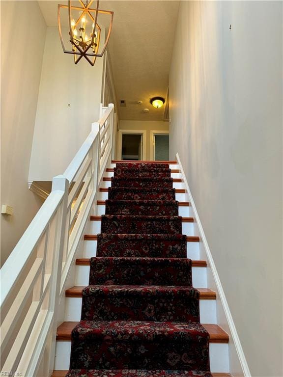 staircase featuring a notable chandelier