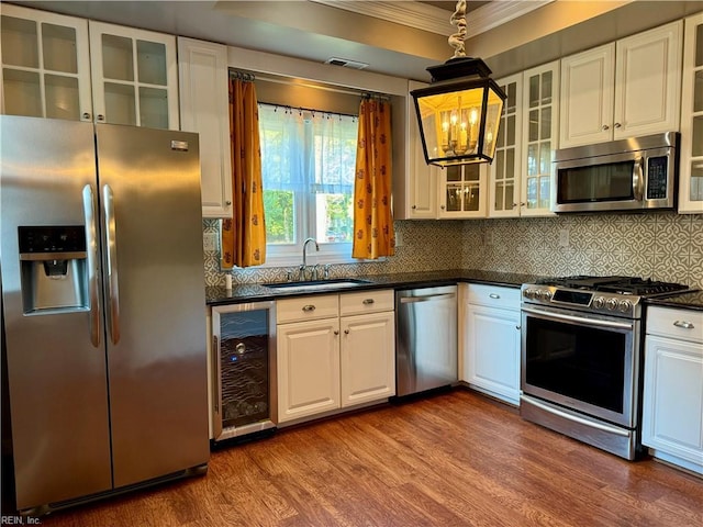 kitchen with sink, appliances with stainless steel finishes, dark hardwood / wood-style flooring, white cabinetry, and beverage cooler