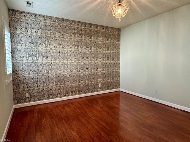 unfurnished room with hardwood / wood-style floors and a textured ceiling