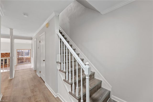 staircase featuring hardwood / wood-style floors and crown molding