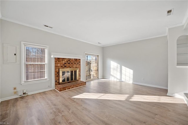 unfurnished living room with electric panel, crown molding, a fireplace, and light wood-type flooring