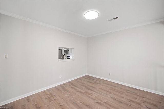 spare room featuring crown molding, sink, and light hardwood / wood-style floors