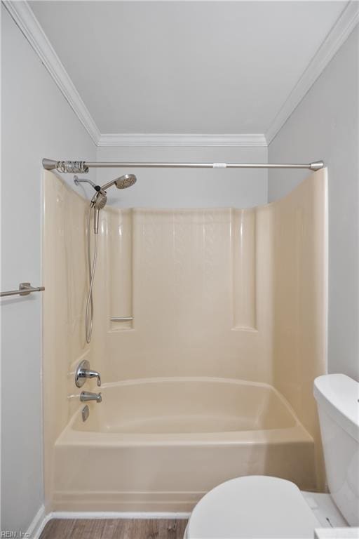 bathroom with bathtub / shower combination, hardwood / wood-style floors, toilet, and ornamental molding