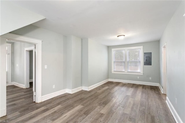 unfurnished room featuring electric panel and dark wood-type flooring