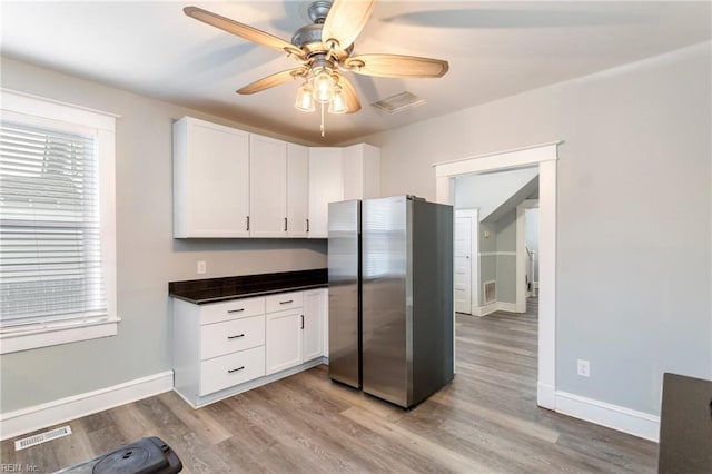 kitchen featuring white cabinetry, stainless steel refrigerator, ceiling fan, and light hardwood / wood-style floors