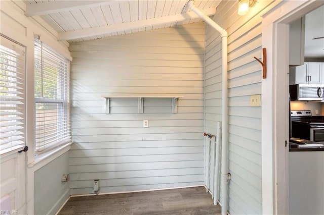 laundry room with dark hardwood / wood-style flooring and wooden walls