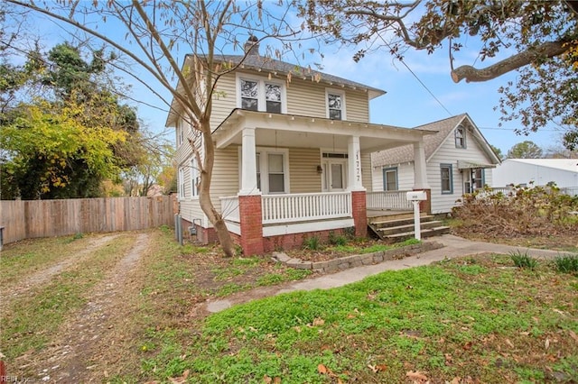 bungalow with covered porch and a front lawn