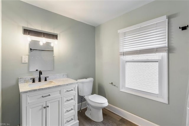 bathroom featuring hardwood / wood-style flooring, vanity, toilet, and a wealth of natural light