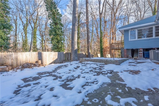 yard layered in snow featuring central air condition unit