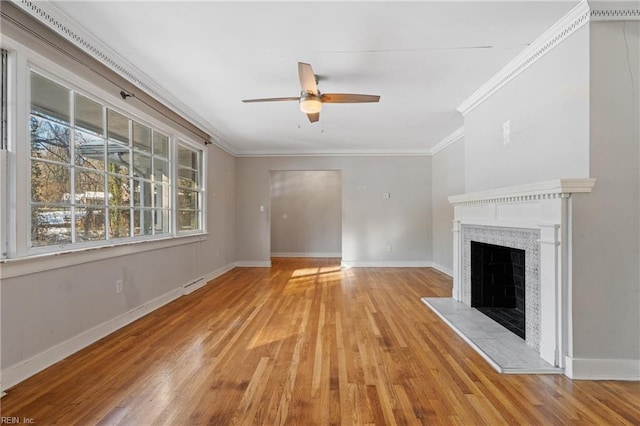 unfurnished living room featuring light wood-type flooring, ceiling fan, crown molding, and a tile fireplace