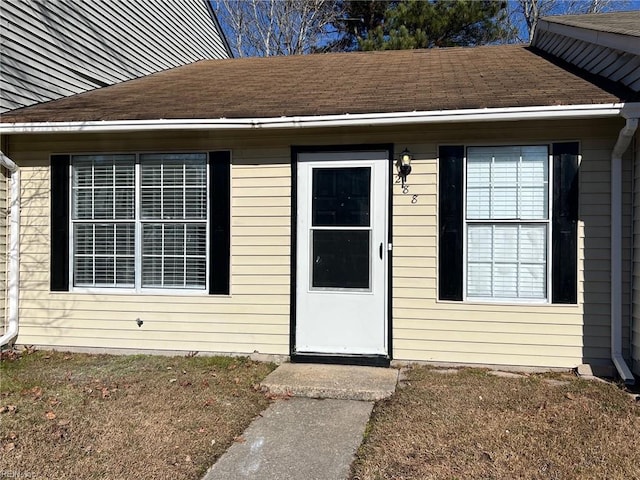 entrance to property featuring a lawn