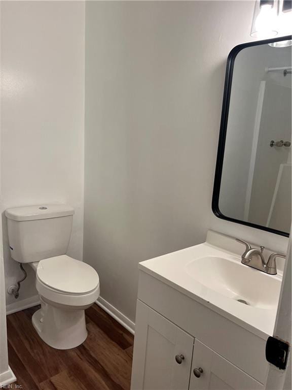 bathroom featuring wood-type flooring, vanity, and toilet