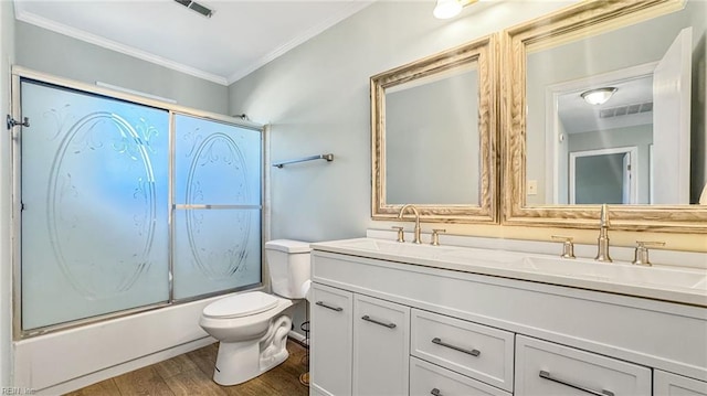 full bathroom with vanity, shower / bath combination with glass door, crown molding, toilet, and wood-type flooring