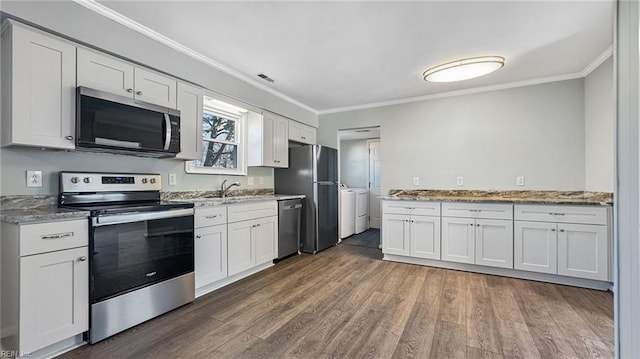 kitchen with washing machine and dryer, white cabinetry, crown molding, and stainless steel appliances