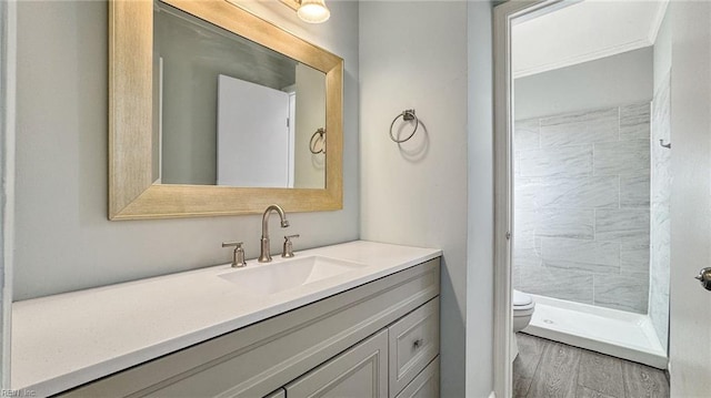 bathroom featuring vanity, toilet, and a tile shower