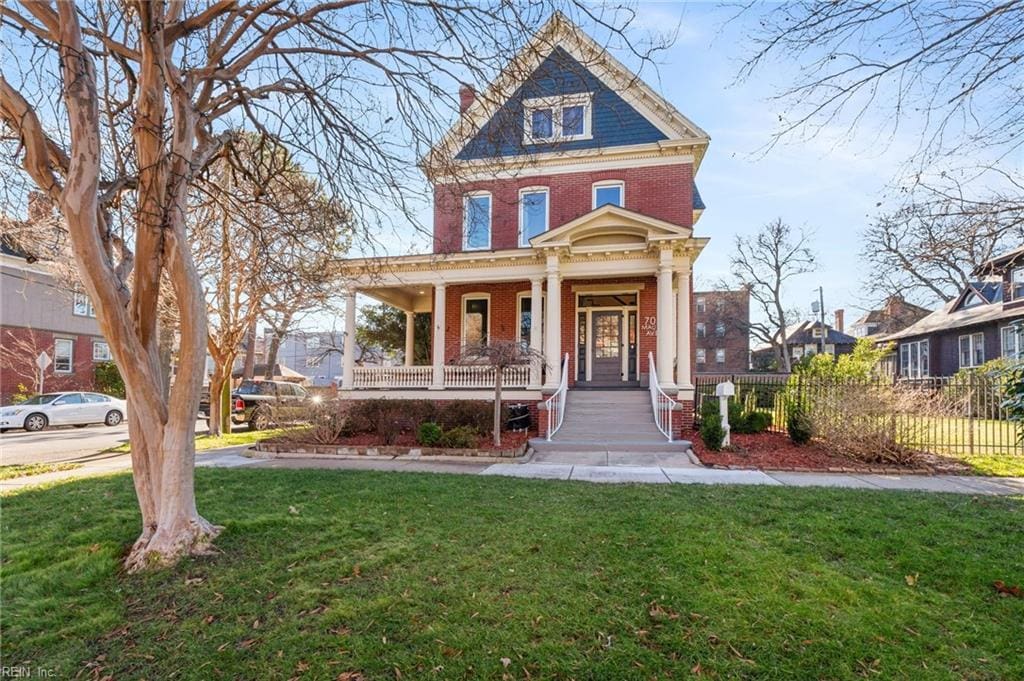 victorian home with covered porch and a front lawn