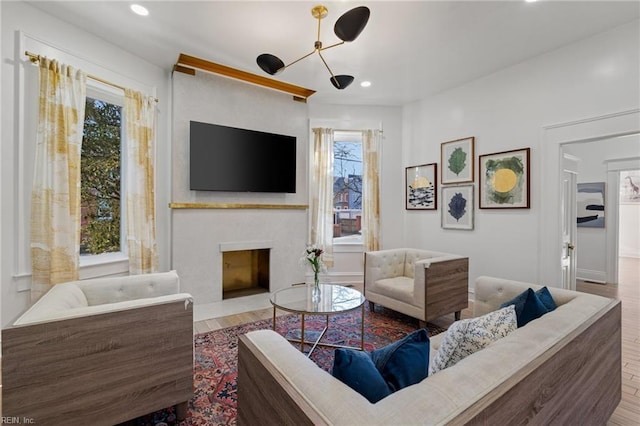 living room featuring a fireplace, hardwood / wood-style flooring, and a notable chandelier