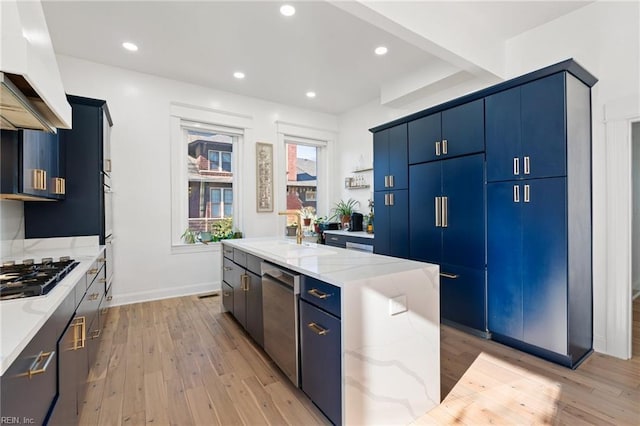 kitchen with blue cabinets, sink, light wood-type flooring, appliances with stainless steel finishes, and a kitchen island