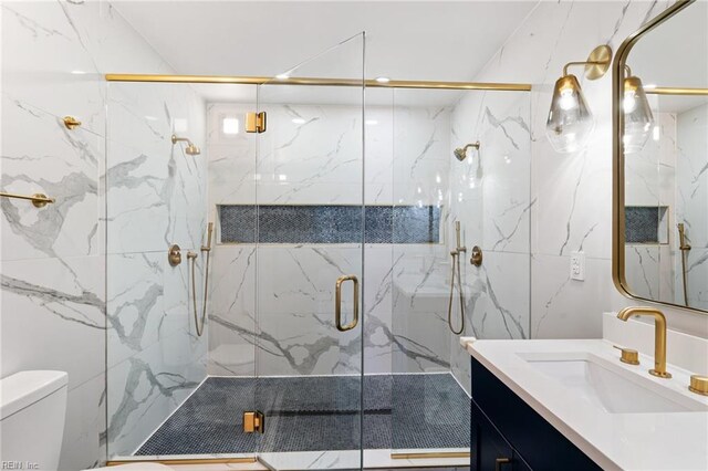 bathroom with vanity, a shower with shower door, and toilet