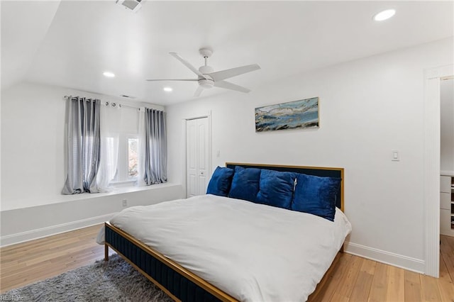 bedroom with hardwood / wood-style flooring, ceiling fan, lofted ceiling, and a closet