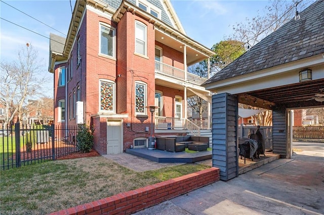 exterior space with a lawn, a patio area, and a balcony