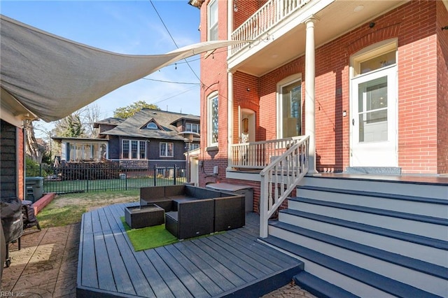 wooden terrace with an outdoor living space