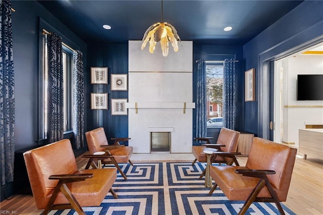 sitting room featuring hardwood / wood-style flooring and a large fireplace