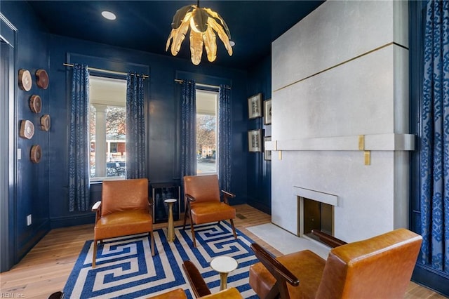 living area with light wood-type flooring and a large fireplace