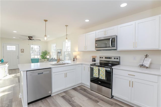 kitchen featuring sink, kitchen peninsula, ceiling fan, white cabinetry, and stainless steel appliances