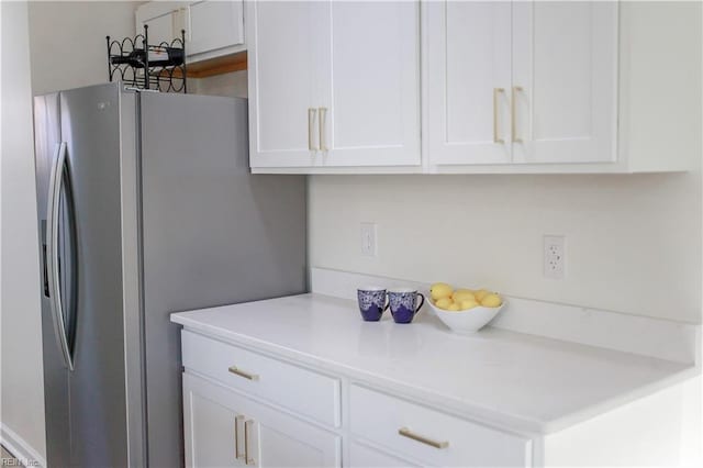 kitchen with white cabinetry and stainless steel refrigerator with ice dispenser