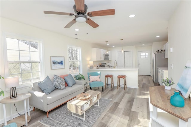 living room featuring light hardwood / wood-style floors and ceiling fan