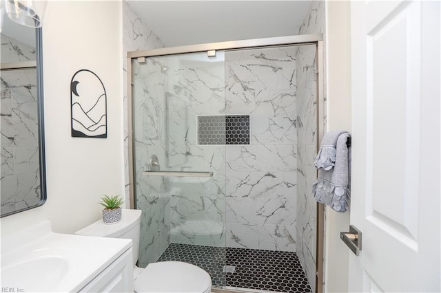 bathroom featuring vanity, toilet, and a shower with door